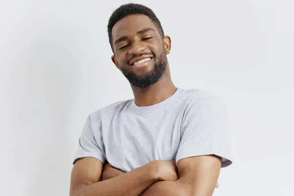 stock image Confident bearded man in a grey t-shirt standing casually against a clean white background, exuding self-assurance and simplicity.