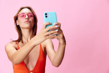 Mayo giymiş çekici bir kadın. Güneşin altında güzel bir pembe selfie çekiyor.