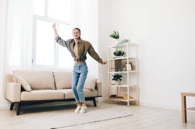 Neşeli Zıplama: Neşeli Bir Kadın Mutlu Evinde Müzikle Dans Ediyor