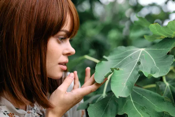 stock image Woman enjoying the aroma of fresh leaves in a lush garden setting