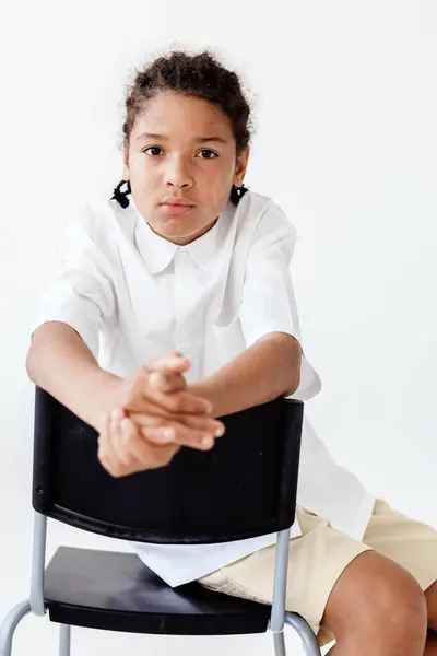 stock image Confident young boy with arms crossed in front of blank white background exudes self-assurance and determination.