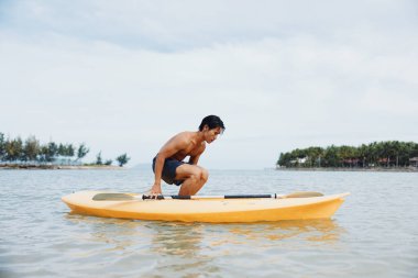Mutlu Asyalı Adam Tropikal Sahilde Aktif Kayak Macerası Yapıyor
