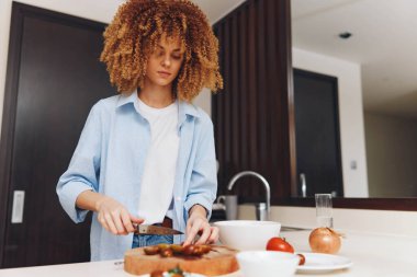 Güzel, Afro-Amerikan bir kadın evdeki mutfakta geleneksel yemekler hazırlıyor.