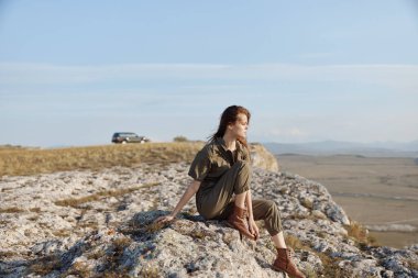 Doğanın muazzam güzelliğini ve bir uçurumun kenarında bir araba ve bir uçurumun kenarındaki macerayı düşünen bir kadın.