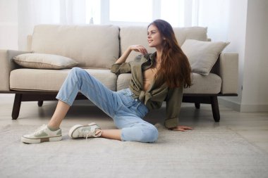 Rahat ev konforu: Modern koltukta rahatlatıcı kadın, huzur dolu evin tadını çıkarıyor