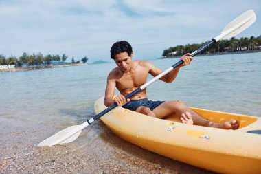 Mutlu Asyalı Adam Tropikal Sahilde Kayak yapıyor, Yaz Tatilinin tadını çıkarıyor