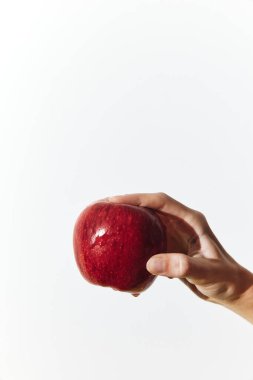 Beyaz arka planda olgun kırmızı bir elma tutan adam sağlıklı yemek ve beslenme kavramları için mükemmeldir. kopyalama alanı elmanın ortasında ve kişinin elinde mevcut.