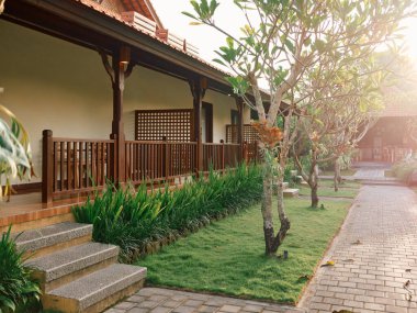 Tuhaf ahşap bir sundurma ve korkuluk güneşli bir günde büyüleyici bir evi vurguluyor, samimi ve davetkar bir atmosfer yaratıyor..