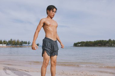 Sahilde Koşan Kaslı Asyalı Sporcu: Fitness Yaşam Tarzını Kucaklamak