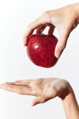 Bir elinde kırmızı bir elma tutan ve diğer elinde ona dokunan kişi..