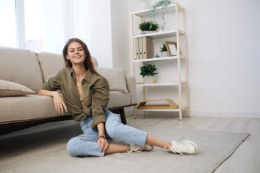 Modern bir dairede rahat bir koltukta dinlenen mutlu kadın.