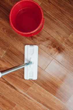 Ahşap zemini paspas ve bir kova suyla temizlemek. Bir insan kiri ve kiri temizlemek için yerleri ovalayıp, onu pırıl pırıl ve tertemiz bırakıyor..