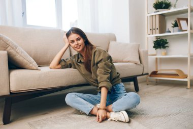 Konforlu Daire: Huzurlu Oturma Odasında Modern Koltukta Rahatlayan Mutlu Kadın