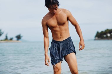 Tropikal Sularda Yüzen Adam: Mutlu Asyalı Tatilci Mutlu Okyanusun Tadını Çıkartıyor