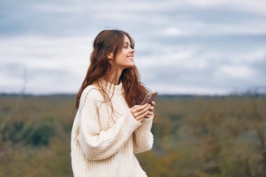 Dağ Maceracısı: Özgürlüğü ve Bağlantıyı Saran Gülümseyen Bir Kadın, Cep Telefonu ile Yürüyüş Yolculuğunu Çekiyor