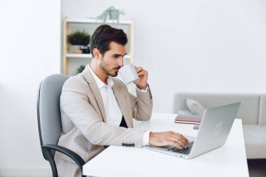 İçeride kendine güvenen beyaz işadamı gülümseyen iş adamı kahve yöneticisi görünümlü ofis sahibi modern bilgisayar portresi bilgisayar videosu diyen adam.