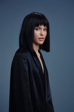 Siyah Bob saç stili, siyah ceket, siyah kadın, koyu arkaplan, siyah ceketli, siyah kısa saçlı genç bir kadının portresi, koyu renk bir portreye karşı dikkat çekici bir poz veriyor.