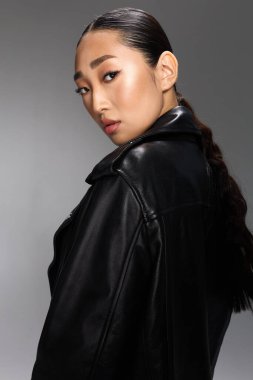 Asyalı kadın, siyah deri ceketli, at kuyruklu, kameraya poz veren..