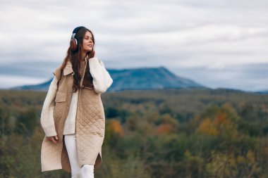 Dağ Melodileri: Özgür Ruhlu Bir Kadının Doğanın Ortasında Müzik Dinleyen Neşeli Yolculuğu.