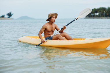 Mutlu Asyalı Adam Tropikal Sahilde Kayak Macerasının keyfini çıkarıyor