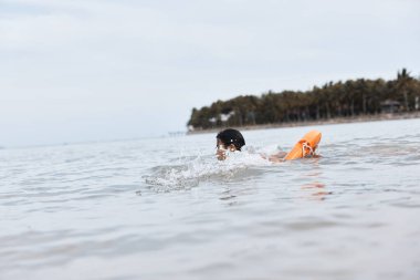 Cankurtaranlar: Mayo giyen Asyalı Adam Sahilde Hayat Kurtarıyor, Güvenliği Sağlıyor ve Yaz Tatilinin Tadını Çıkartıyor