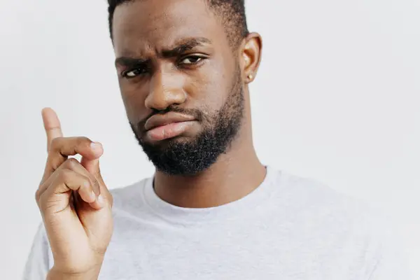 stock image Bearded man with intense expression, angrily pointing to his temple, conveying frustration and disbelief in a stressful scenario.