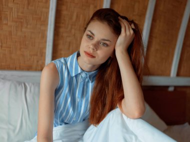 Genç bir kadın gergin görünür, gözleri kapalı, elleri başının üstünde, derin düşüncelere dalmış..