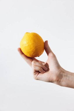 Kopya alanı olan beyaz bir arka planda limon tutan kişi. Reklam, yiyecek ve içecek kavramları veya tasarım projeleri için mükemmel.