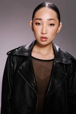 Asyalı kadın siyah deri ceket kameraya poz veren eller moda güzeli..
