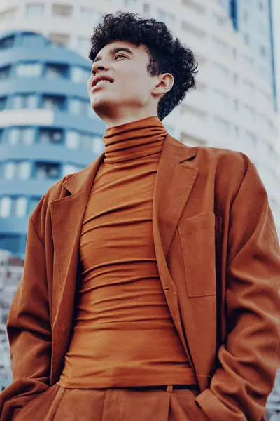 stock image A fashionable male model poses confidently in a sleek brown ensemble, highlighting contemporary style