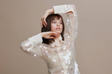 Pullu gömlekli bir kadın, elleri kalçasında kameraya poz veriyor, başı yana eğik, zarif ve kendine güvenen bir anı yakalıyor, moda, cazibe veya şık bir portre teması için mükemmel.