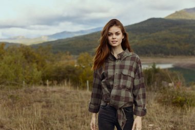 Ekose gömlekli ve kot pantolonlu kadın Dağ Gölü 'nün yanında Doğal Güzellik ve Huzur Macerası Sahnesinde