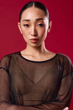 Saf bluzlu şık Asyalı kadın kırmızı arka planda poz veriyor. Çevrimiçi pazarlar veya sosyal medya için moda kavramı.