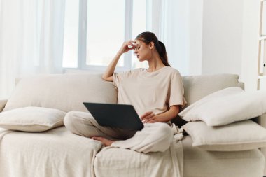 Evde dizüstü bilgisayar kullanan gülümseyen kadın, Modern Ev Ayarları 'nda Serbest Teknoloji İşi Keyfi Yapıyor