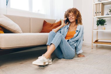 Mutlu Kadın Cep Telefonu Tutuyor ve Evdeki Konforlu Koltukta Rahatlıyor, Gülümsüyor ve Çevrimiçi Oyun Keyifli