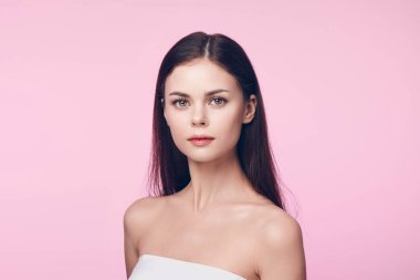 Çekici, kahverengi saçlı, pembe arka planda fotokopi çeken genç bir kadın. Reklamcılık veya güzellik kavramları için güzel bir resim.