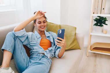 Gülümseyen Kadın Cep Telefonunu Tutuyor, Çevrimiçi Oyunun ve Sohbetin keyfini çıkartıyor