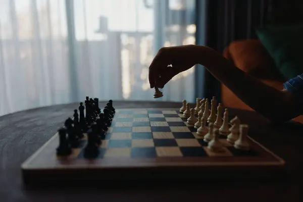 stock image Strategic chess game being played on table with window in background, intellectual pursuit and decisionmaking concept