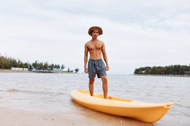 Güneşte Kano Eğlencesi: Asyalı Adam Aktif Sahil Tatilinin Tadını Çıkartıyor