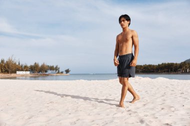 Tropik Plaj Tatilinin tadını çıkaran kaslı Asyalı Adam