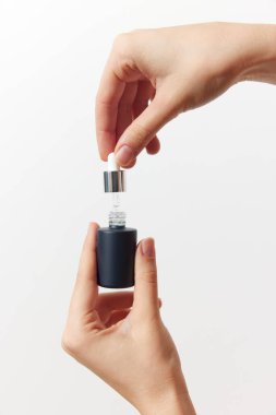 Elinde küçük parfüm şişeleri tutan iki kişi..