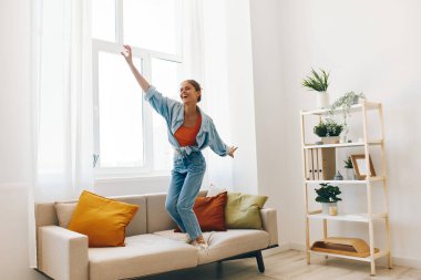 Neşeli Zıplama: Neşeli Bir Kadın Dans Ediyor ve Mutlu Bir Evde Şarkı Söylüyor