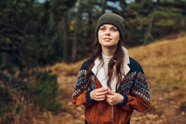 Huzurlu bir ormanda sonbahar renklerinin tadını çıkaran güzel genç bir kadın. Yaşam tarzı ve rahatlama temalı tasvirler için sakin doğa güzellik portresi konsepti hazırlıyor.