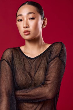 Moda çekimlerinde kırmızı arkaplanda poz veren katıksız asyalı kadın..