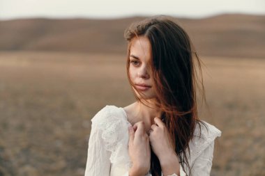 Huzur ve beyaz elbiseli güzel bir kadın ellerini göğsüne koymuştu.