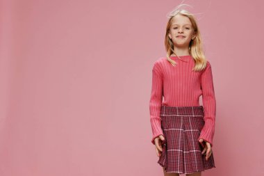 Şık Pembe Moda 'lı mutlu liseli kız güzel gülüşlü, genç kız pembe arka planlı bir stüdyoda poz veriyor şık kıyafeti neşeli ve şık kişiliğini yansıtıyor.,