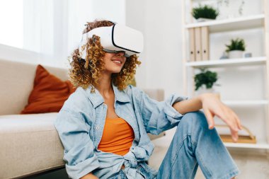 Gülümseyen Kadın Evde Fütürist VR Gözlükleri ve Denetleyicisiyle Sanal Gerçekliğin tadını Çıkartıyor