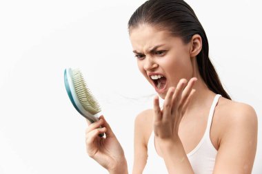 Saç fırçası tutarken saç dökülmesine yoğun tepki gösteren, beyaz bir geçmişi olan, duygularını ön plana çıkaran, kadınların karşılaştığı yaygın saç bakım sorunlarını gözler önüne seren bir kadın.