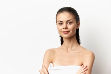 Açık tenli ve doğal güzelliğe sahip genç bir kadının çarpıcı portresi, sade beyaz bir arka plana, güzellik ürünleri, cilt bakımı ve sağlıklılık kavramları için ideal.