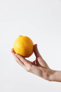 Beyaz arka planda limon tutan bir adam. Çeşitli tasarım projeleri için basit ve temiz bir resim.